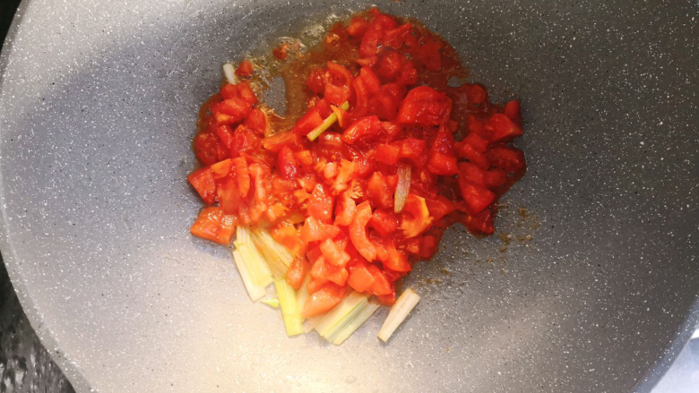 西红柿鸡蛋挂面,倒入切碎的西红柿炒出红油,再倒入适量清水。