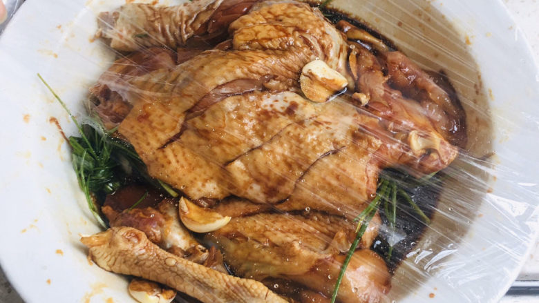 电饭煲煲鸡,拿出保鲜膜,把鸡包好放入冰箱冷藏室1小时