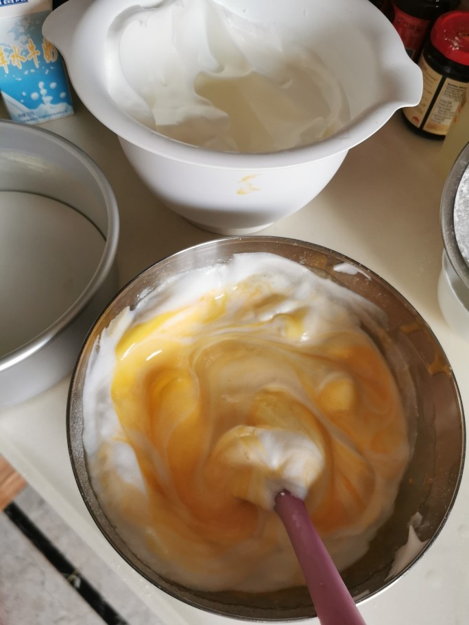 戚风蛋糕【低糖低脂,爱美女生的生日蛋糕】,用橡胶搅拌刀把约1/3的蛋清泡与蛋黄面粉浆混合,注意:千万不能打转搅动,要从底向上翻,搅拌刀只能向下插。