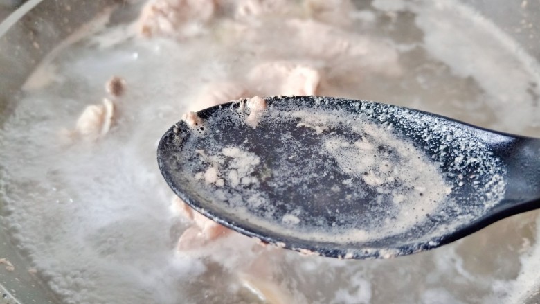 海带炖排骨,排骨焯水的时候用勺子撇去浮沫。