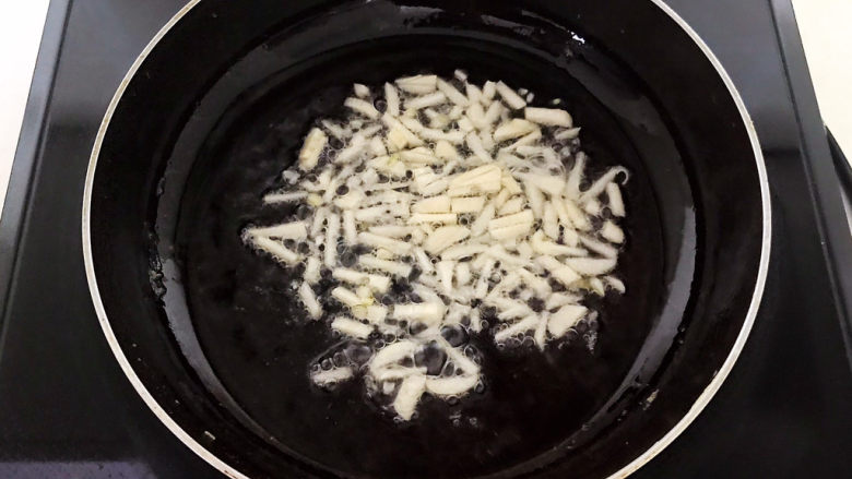 豇豆炒鸡蛋,炒锅烧热后加入花生油,油烧热后加入蒜丝,炒出香味