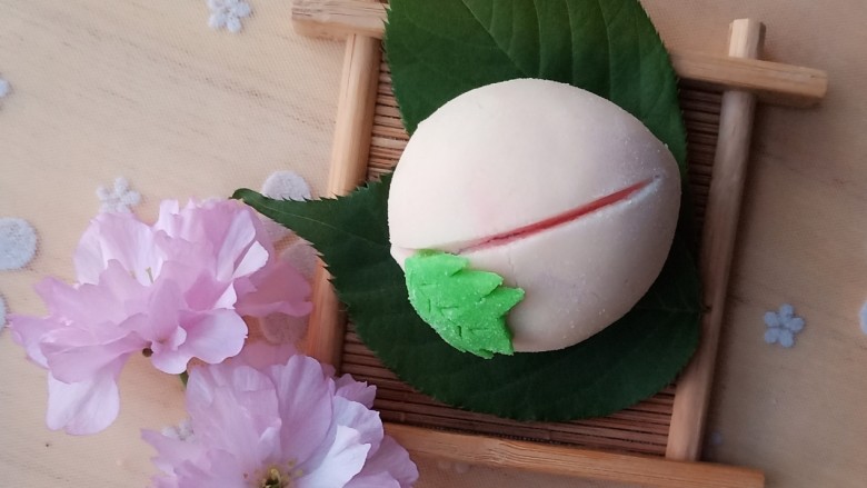 和果子-福桃,再用双手揉成桃子的形状,一头圆一头略微有点尖。从中间位置划开一个口。