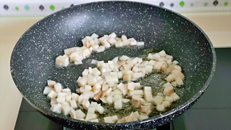 杏鲍菇炒鸡蛋,起油锅,加入杏鲍菇丁煸炒。