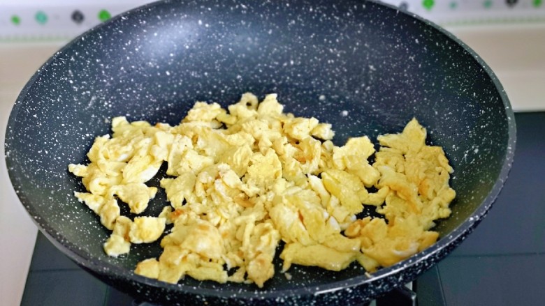 杏鲍菇炒鸡蛋,待蛋液表面凝固后用铲子铲碎,盛出备用。