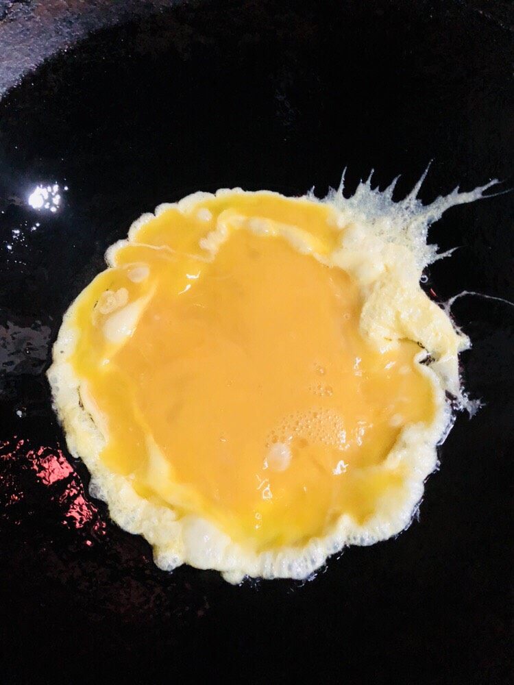 杏鲍菇炒鸡蛋,倒入鸡蛋液,可以转一下锅让蛋液在锅内更均匀