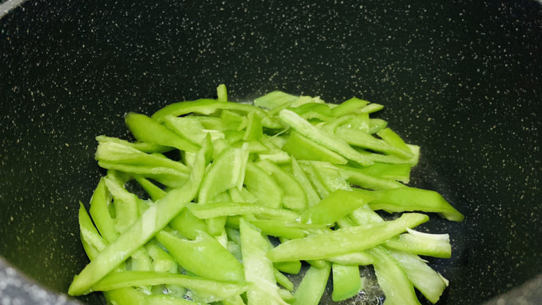 青椒炒猪肚,大火热油,倒入青椒;