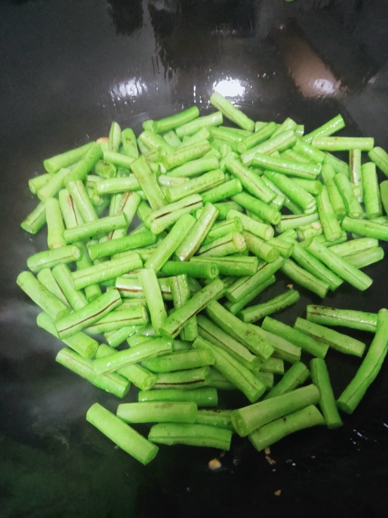 豇豆炒鸡蛋,起锅烧油,待油锅起小泡放入豇豆翻炒