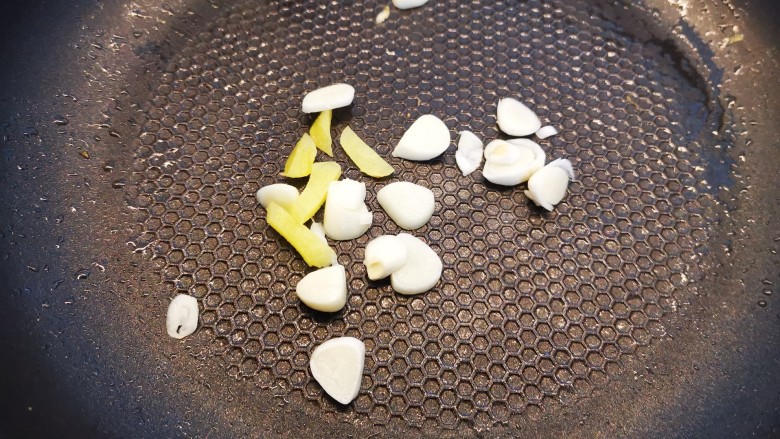 豇豆炒鸡蛋,锅中加入少许食用油,加姜蒜片下入爆香