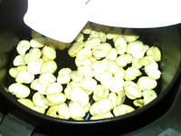 油炸蚕豆,将拌好油的蚕豆瓣倒入炸锅网篮,铺开,推入炸锅