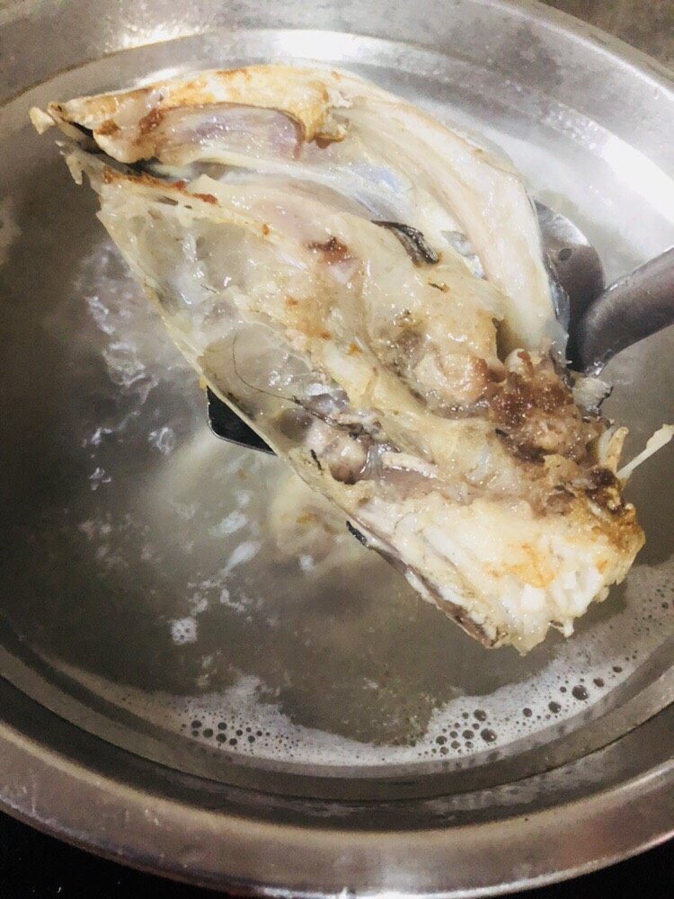 海带豆腐汤,水开后放入煎好的鱼头,为了减少油脂摄入,煎鱼的油就不要了。