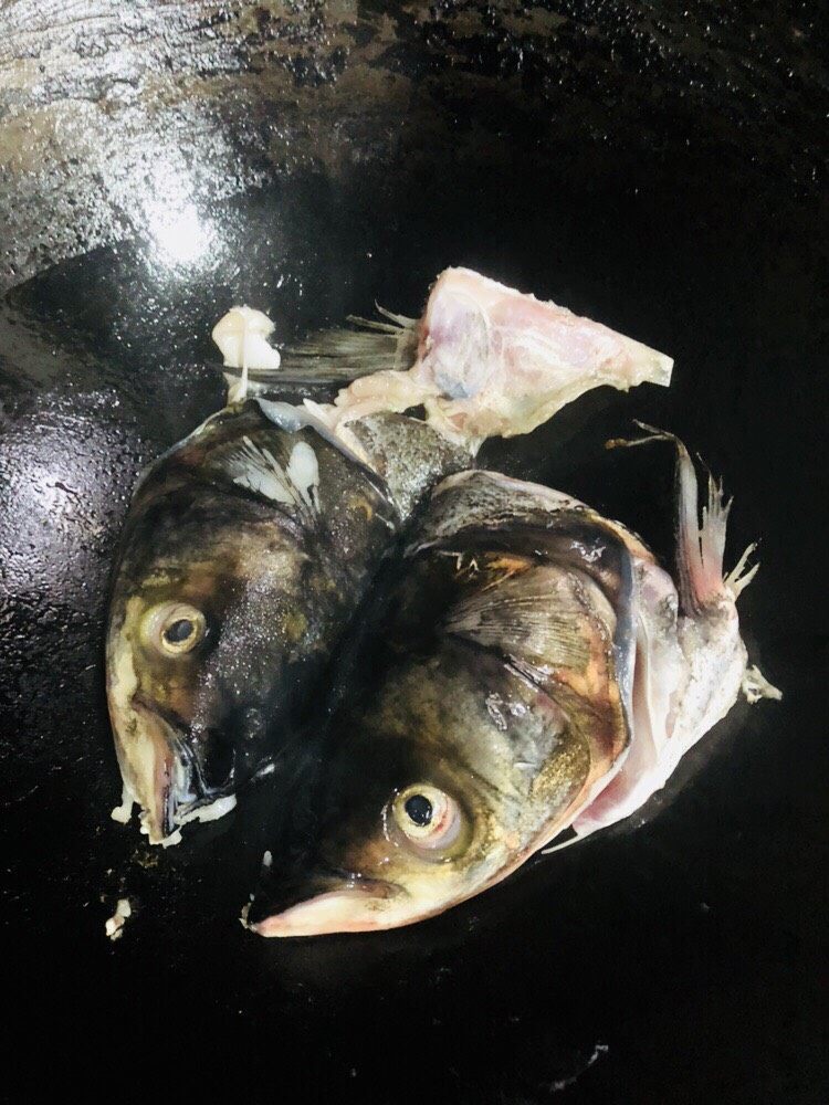 海带豆腐汤,转中小火,加入鱼头煎至金黄色。