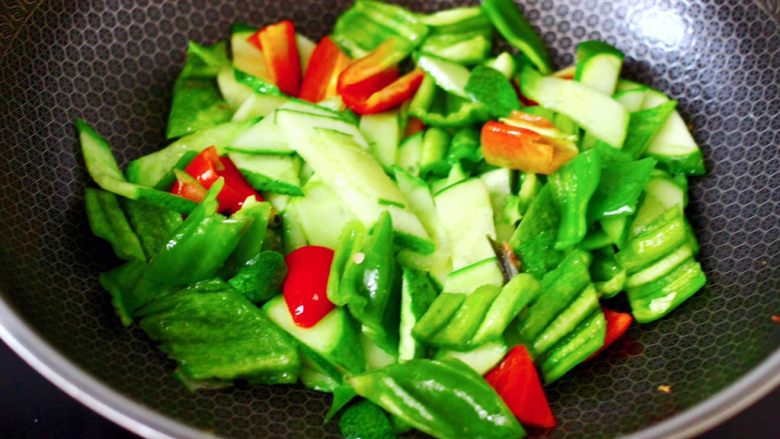 鸭蛋黄瓜炒双椒,加入青红辣椒片,继续大火翻炒片刻。