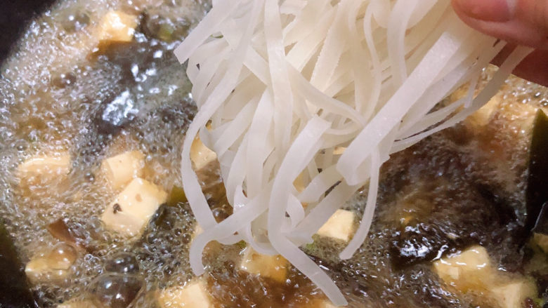 海带豆腐汤,海带豆腐汤中放入宽粉,盖盖儿中火炖煮10分钟。