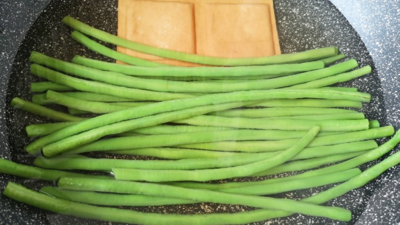 豇豆炒鸡蛋,锅内放水烧开,下入豇豆和豆腐干焯水至断生。