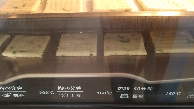 香葱苏打饼干,放入提前预热好的烤箱中层，160－170度左右，烤十分钟，表面微微上色即可