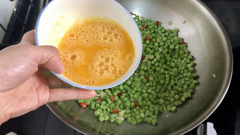 豇豆炒鸡蛋➕春到人间草木知,转小火,把蛋液浇在豇豆上,转动锅子,让蛋液均匀铺在豇豆上