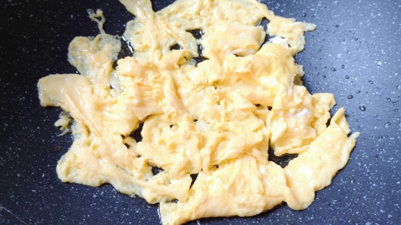 杏鲍菇炒鸡蛋,待蛋液底部凝固以后,用铲子轻轻推动,炒熟盛出备用。