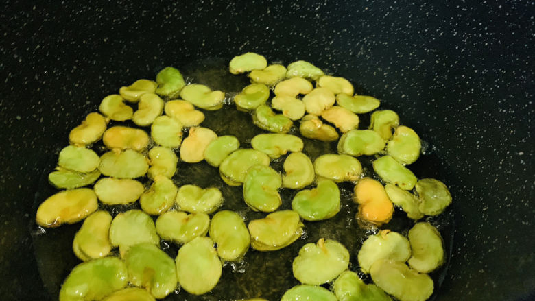 油炸蚕豆,又部分出现黄色,搅动有脆的声音,就可以出锅;