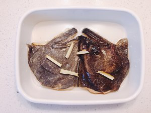 剁椒鸦片鱼头,用剪刀剪去腮,洗净,挤去水分,用清酒、味淋、姜丝、一小勺盐腌15分钟。