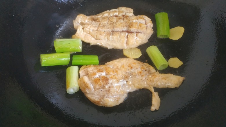 照烧鸡胸肉,放入葱姜,鸡肉两面煎至焦黄