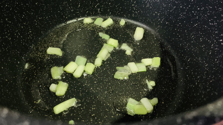 丝瓜炒毛豆,锅里食用油烧热,加入葱白;