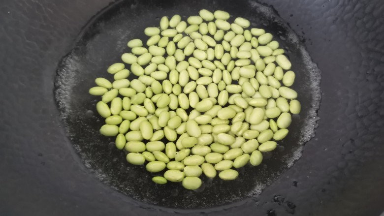 丝瓜炒毛豆,锅里水开加入少许盐,几滴油倒入毛豆焯水5分钟