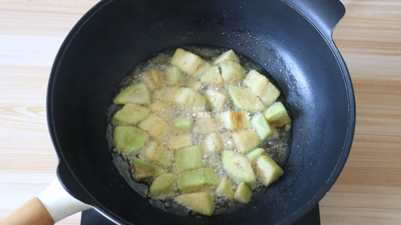 糖醋茄子,
将茄块倒入油锅中炸至表面定型后再翻动，使茄块受热均匀，炸至表面金黄后捞出；