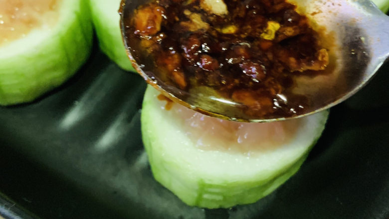 丝瓜酿肉,用勺子舀蒜蓉汁;