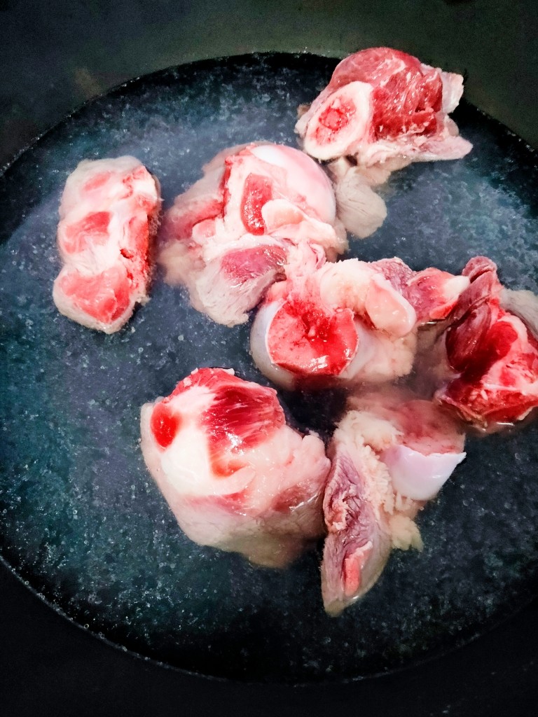 海带筒骨汤,水开后倒出一半水备用,将骨头放入开水锅中