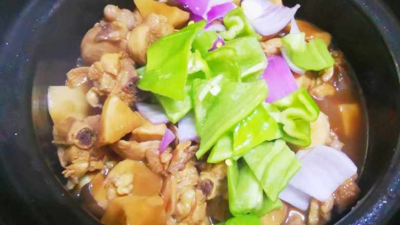 杏鲍菇烧鸡块,转中火继续焖煮,待汤汁收干时,加入洋葱青椒块,转大火翻炒均匀,入味即可出锅
