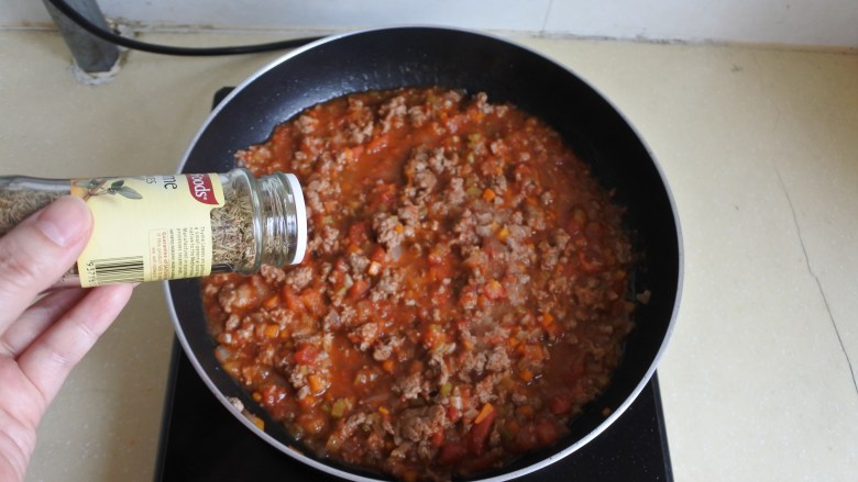 意大利牛肉酱,倒入之前炒好的西红柿酱,依口味放入盐、胡椒碎和百里香调味