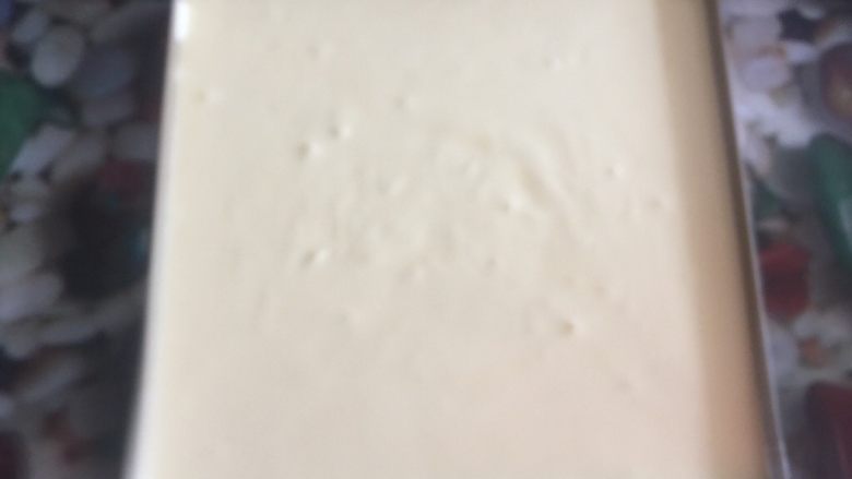 黄桃奶油蛋糕卷,用手轻拍模具底部,震出气泡。