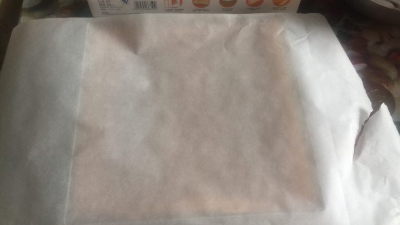 黄桃奶油蛋糕卷,热气完全散去,用手指轻轻向内侧方向剥离蛋糕体,盖上油纸倒扣脱模。