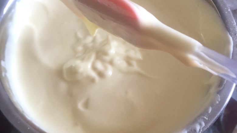 黄桃奶油蛋糕卷,1/3的蛋白加入蛋黄糊里面,用橡皮刮刀抄底翻拌均匀。