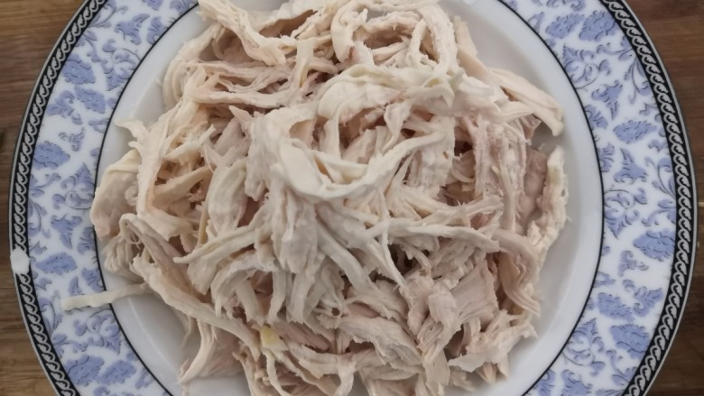 手撕鸡胸肉,鸡胸肉过凉后,捞出,撕成小条,撕的过程中,把筋膜去掉
