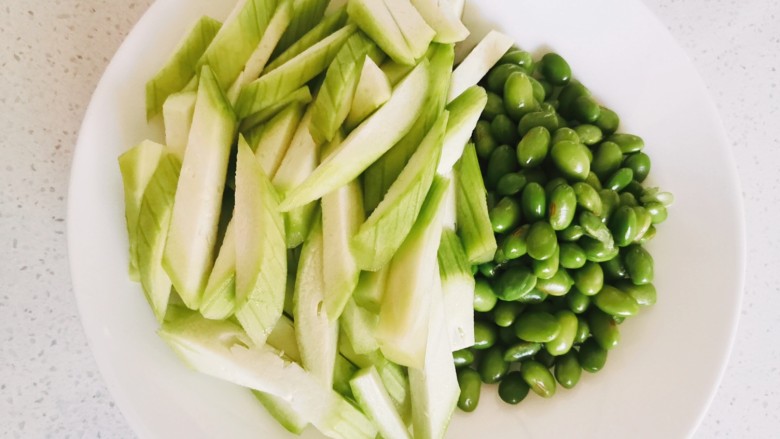 丝瓜炒毛豆,将丝瓜切条,毛豆焯水