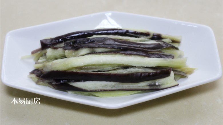 蒜泥手撕茄子,用手将茄子撕成长条,码放在盘中。