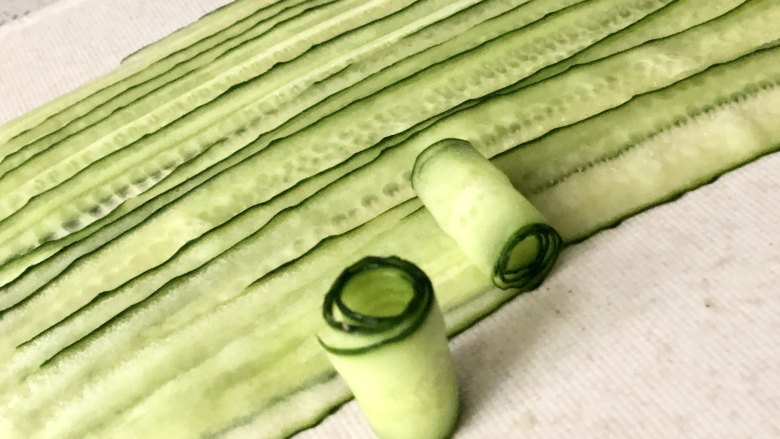 夏季C位凉菜,飘香爽脆的响油黄瓜,从黄瓜片的一头开始卷起来,依次卷好所有的黄瓜。