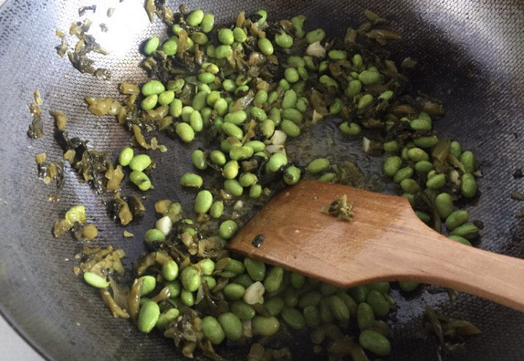 雪菜炒毛豆,最后加入爆炒过的肉丝,加入糖快速翻炒均匀即可出锅。