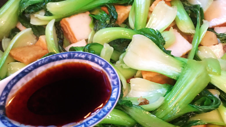 油菜炒鱼豆腐,倒入一勺味极鲜