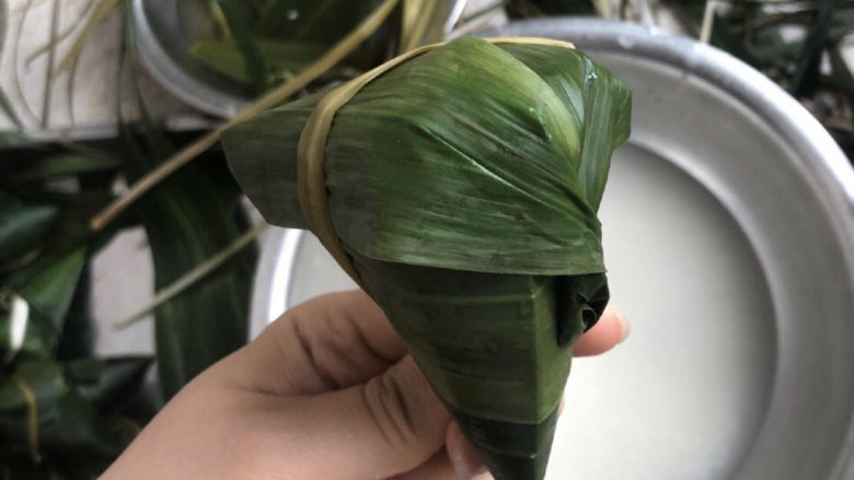 白糯米粽——我的男盆友是白糖君,盖上粽叶以后,将粽叶从边上绕到背后,把麻连绳从上面缠住粽子,在背后将麻连绳和粽叶扭成一股