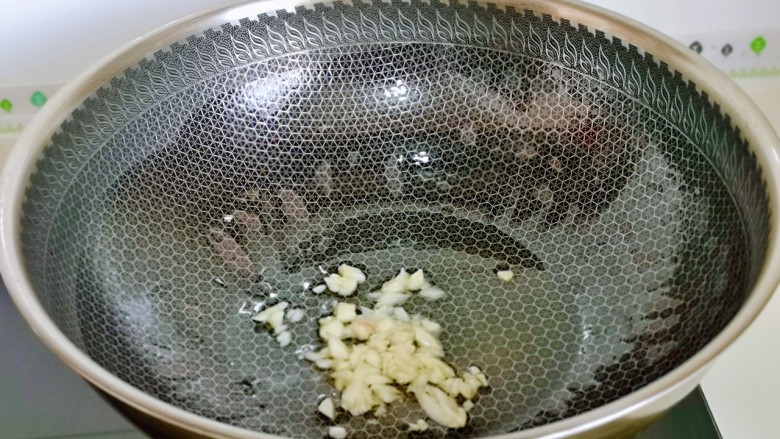 韭菜炒豆芽,起油锅,加入蒜末炒香。