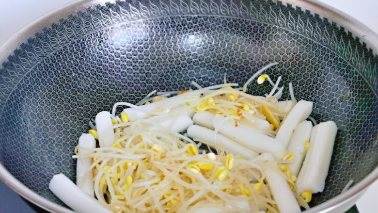 螃蟹炒年糕,另起油锅,加入焯水的豆芽,年糕煸炒。