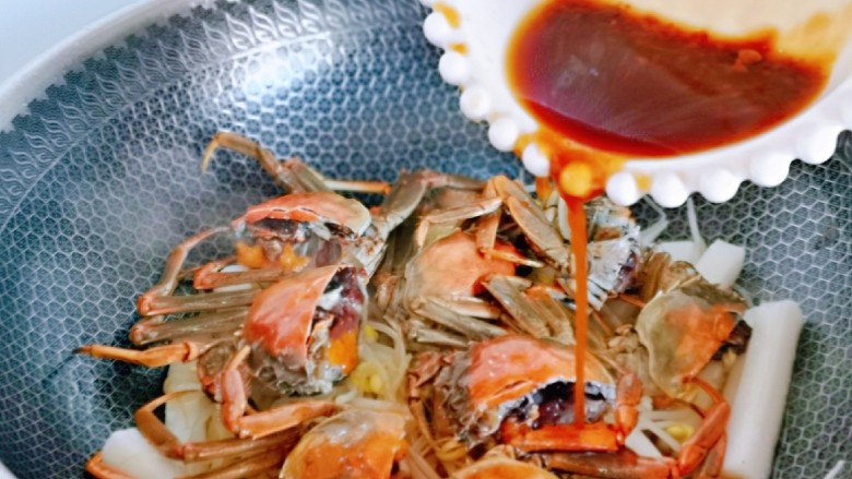 螃蟹炒年糕,淋上调好的酱汁,再加入纯净水,没过食材为佳,大火烧开,转中火煮分钟。