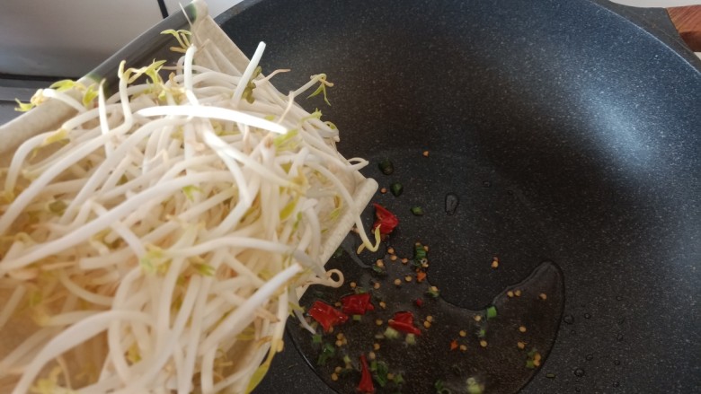 豆芽炒粉条,加入豆芽翻炒两下。豆芽比较容易熟,轻轻炒几下就好,不要炒过了。