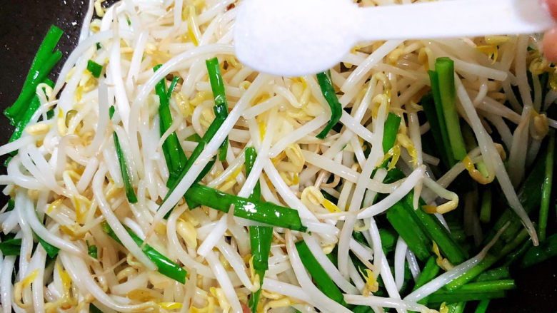 韭菜炒豆芽,加入一少盐,翻炒均匀。