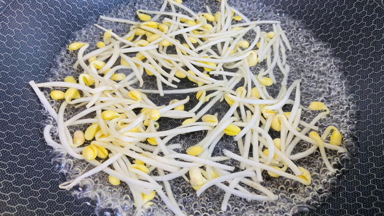 豆芽炒粉条,锅中加入清水大火烧开放入黄豆芽焯烫一分钟,去除豆芽的豆腥气