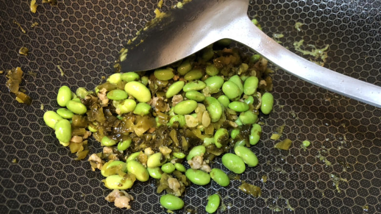 雪菜炒毛豆,雪菜和毛豆充分翻拌均匀,因为雪菜本身较咸,这个菜不用另外加盐