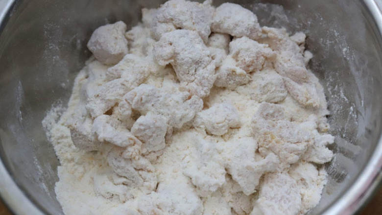 空气炸鸡米花,用手抓揉,让鸡块均匀地裹上面粉,这个动作反复重复,粉类厚厚裹一层。