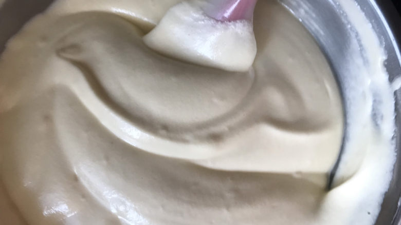 不开裂的海绵纸杯蛋糕(粘米粉版),翻拌好的蛋黄糊再全部倒入蛋白霜中,同样的手法翻拌均匀